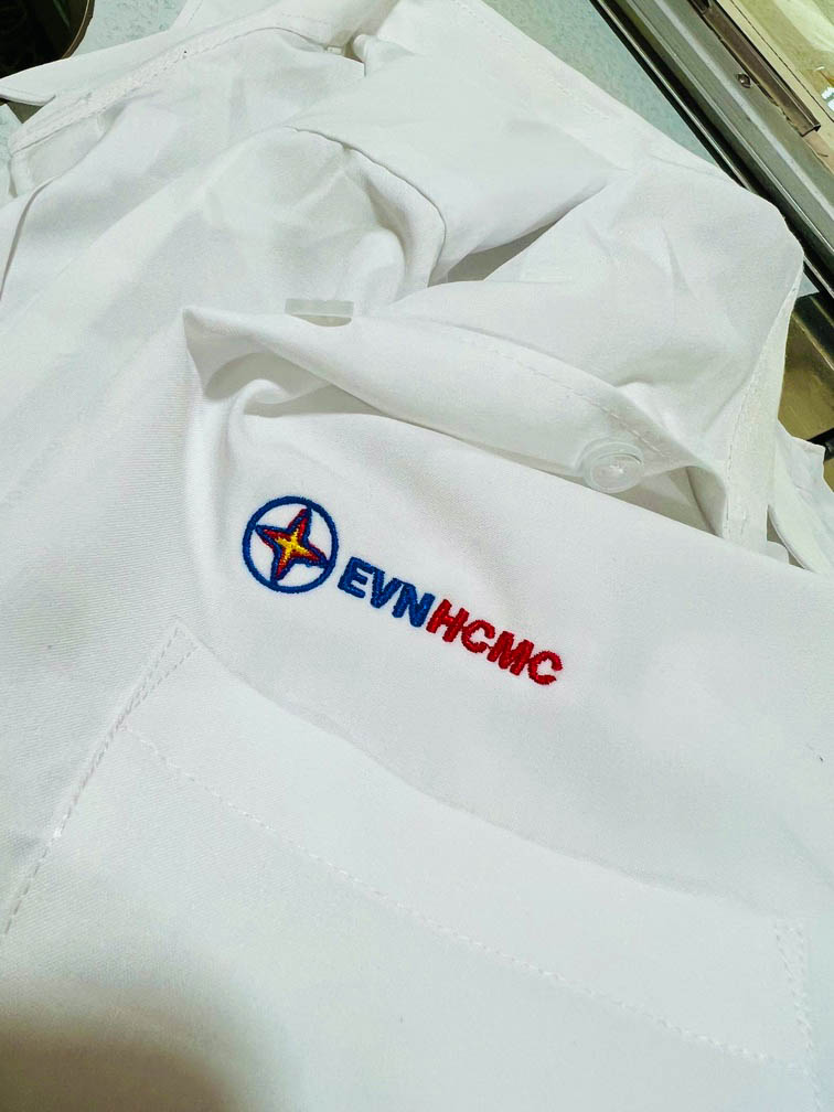 Anh Xuyến thêu logo ENVHCMC trên áo sơ mi